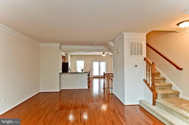 a view of a hallway with wooden floor and staircase
