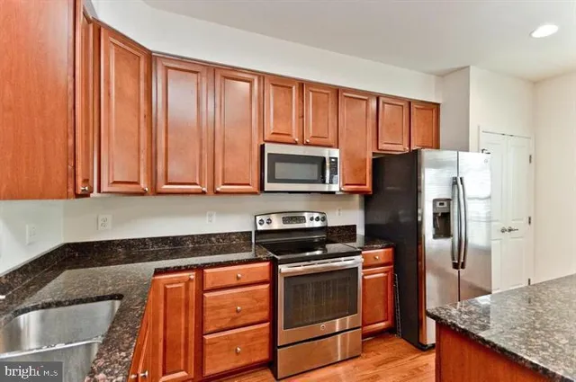 a kitchen with stainless steel appliances granite countertop a refrigerator stove and oven