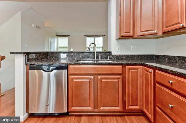 a kitchen with granite countertop a refrigerator and cabinets