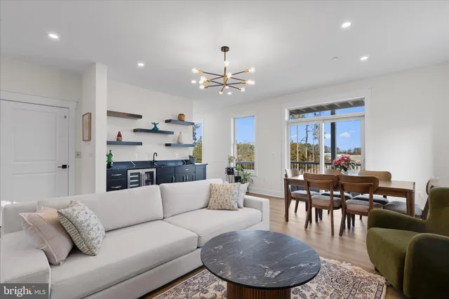 a living room with furniture a dining table and a chandelier