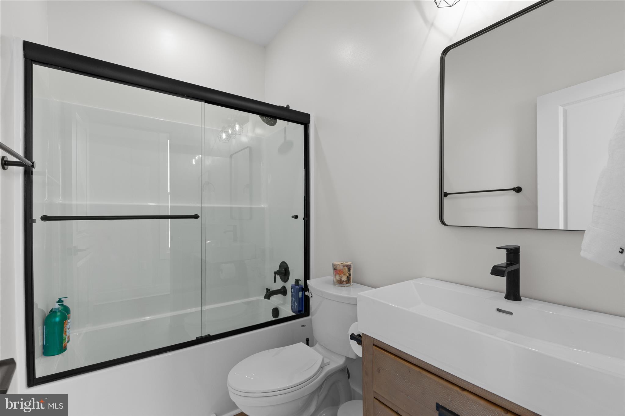 16242 Thomas Road Piney Point, MD 20674 - Photo 29 of 75 a bathroom with a sink a toilet a mirror and shower