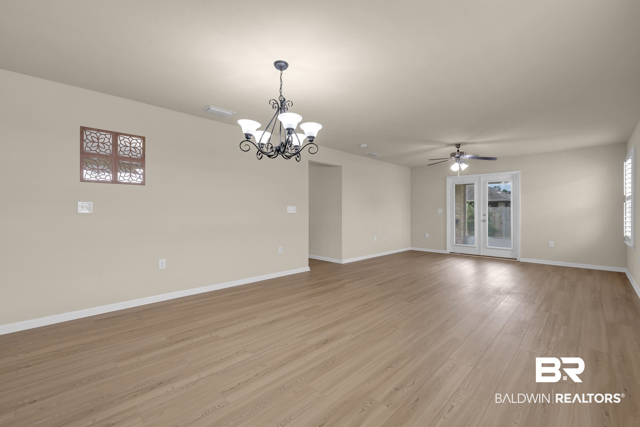 1704 Abbey Loop Foley, AL 36535 - Photo 14 of 38 Spacious room featuring wood-finish flooring, light neutral wall paint, and a traditional chandelier