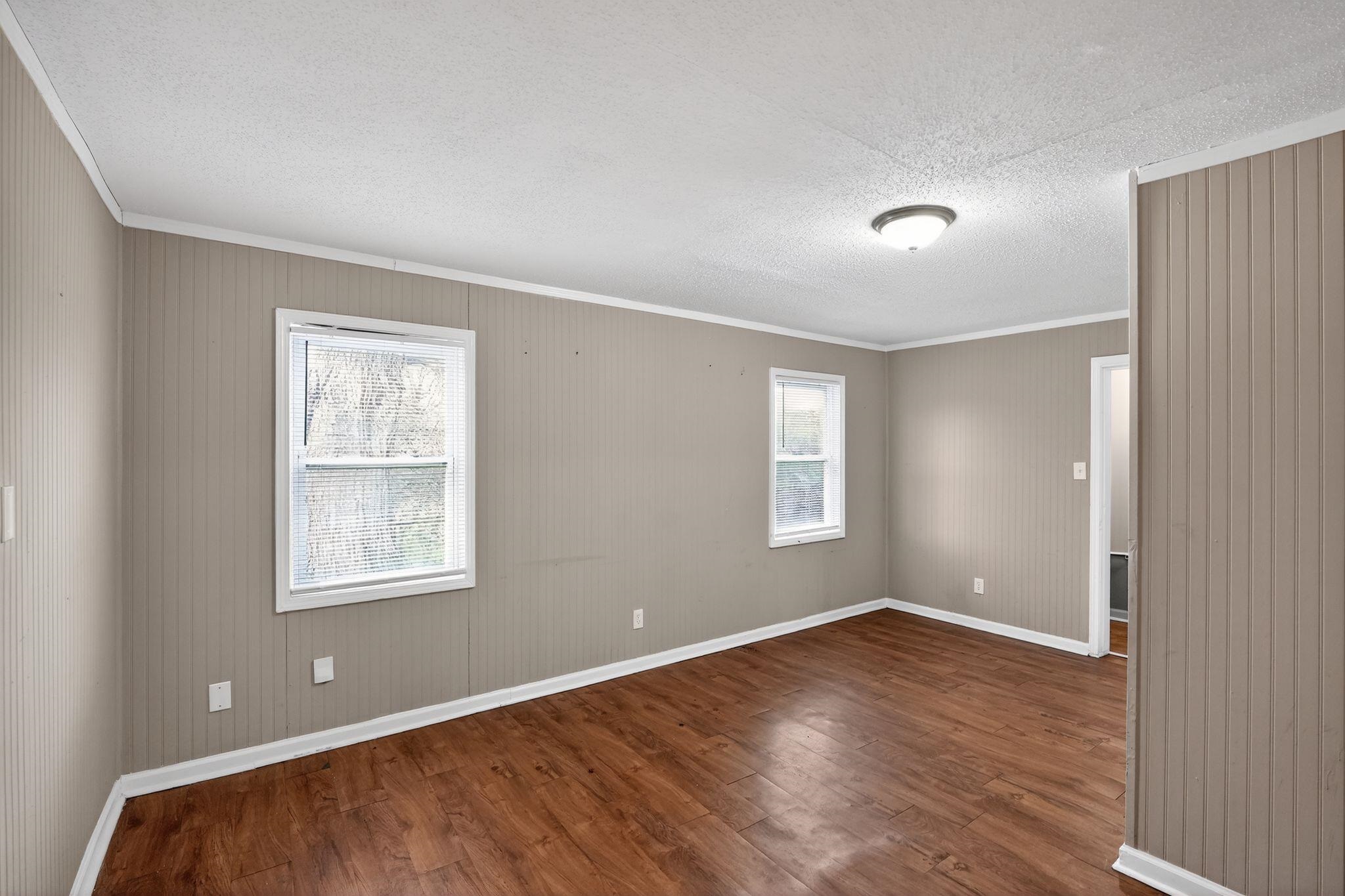 4314 Ford Road Memphis, TN 38109 - Photo 6 of 31 an empty room with wooden floor and windows