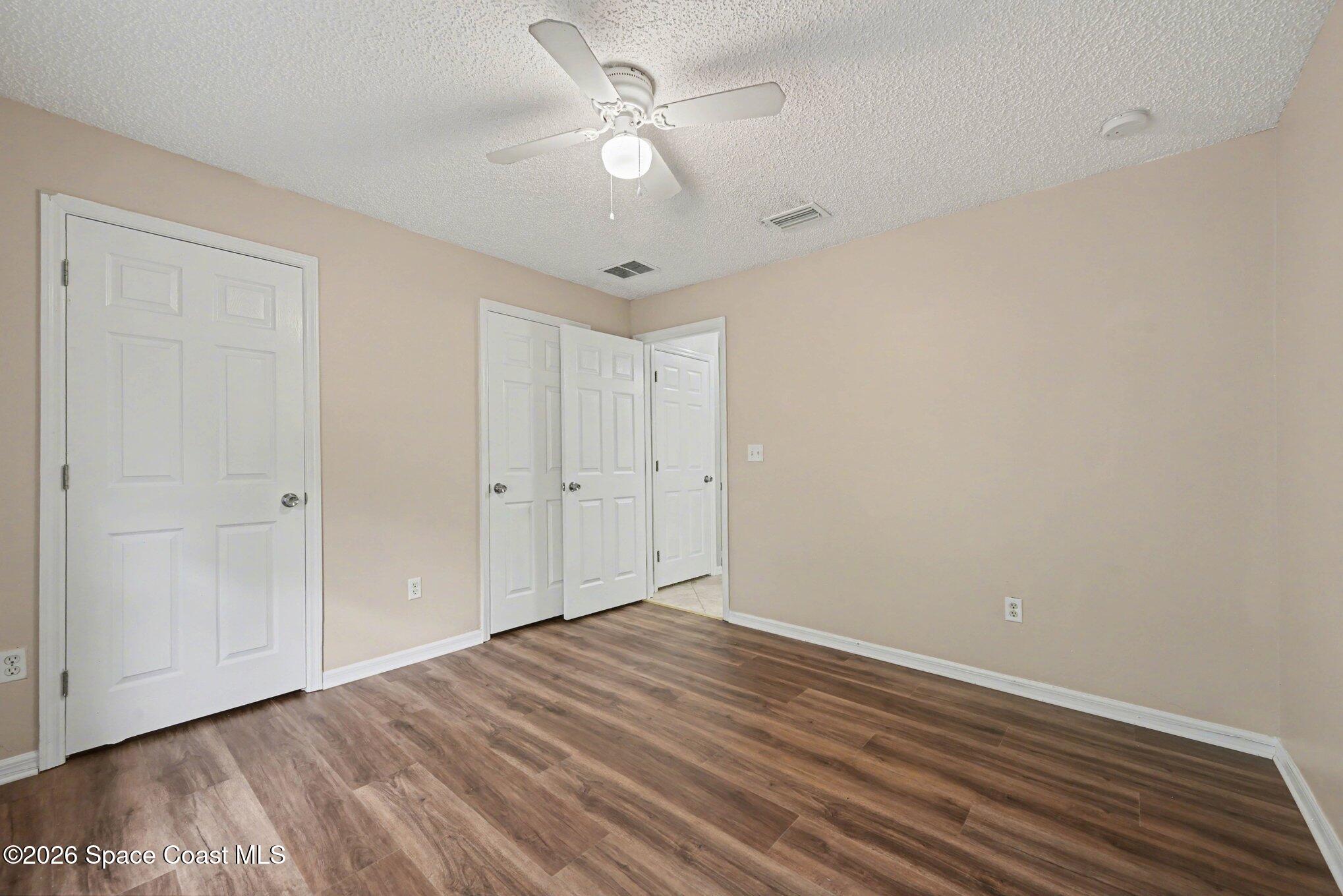 558 Barber Street Sebastian, FL 32958 - Photo 16 of 25 a view of a room with wooden floor and a ceiling fan