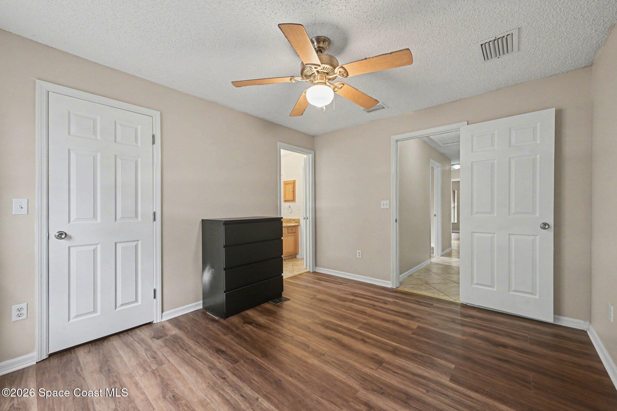 558 Barber Street Sebastian, FL 32958 - Photo 18 of 25 a view of an empty room with wooden floor and a ceiling fan