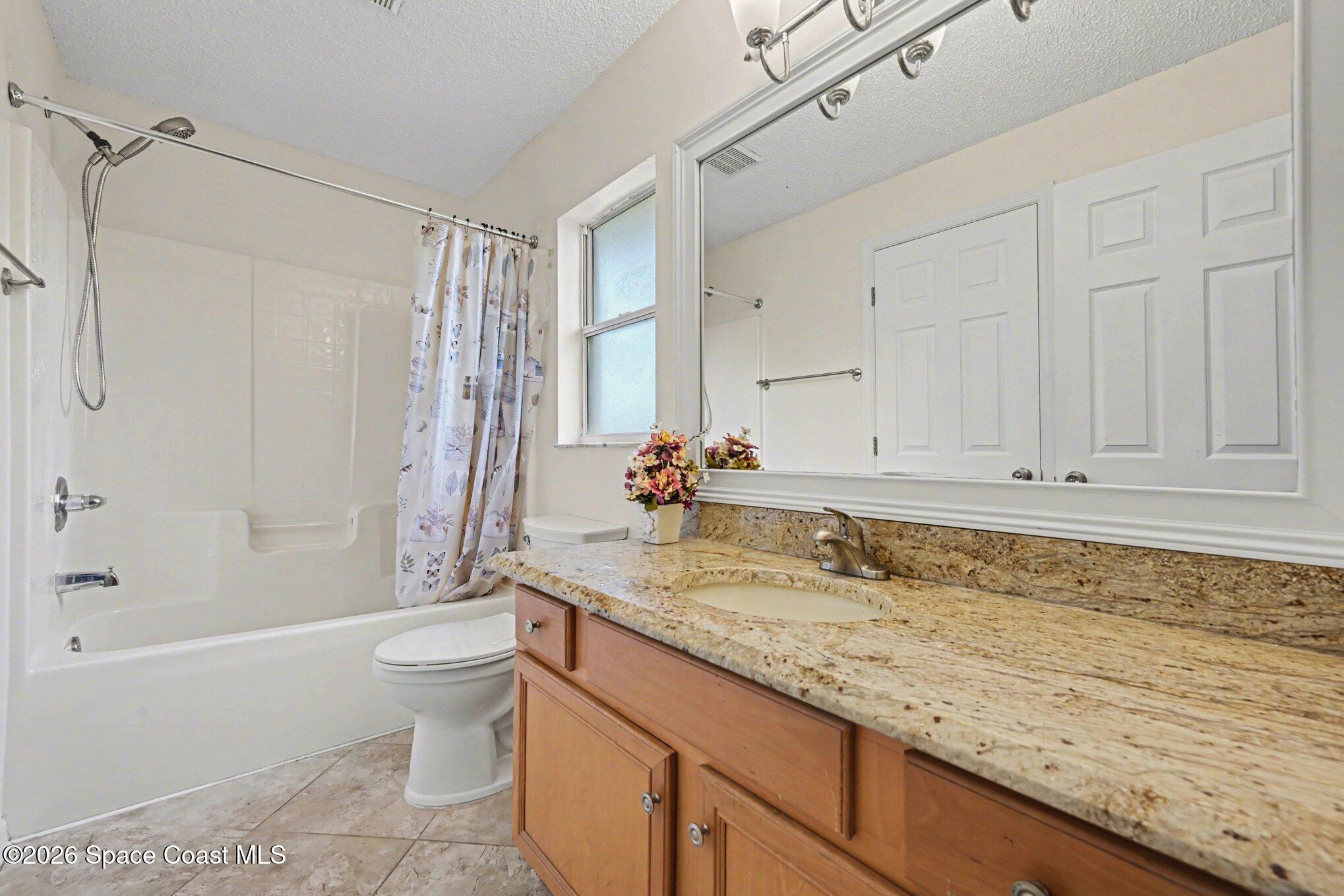 558 Barber Street Sebastian, FL 32958 - Photo 21 of 25 a bathroom with a granite countertop sink a toilet and bathtub