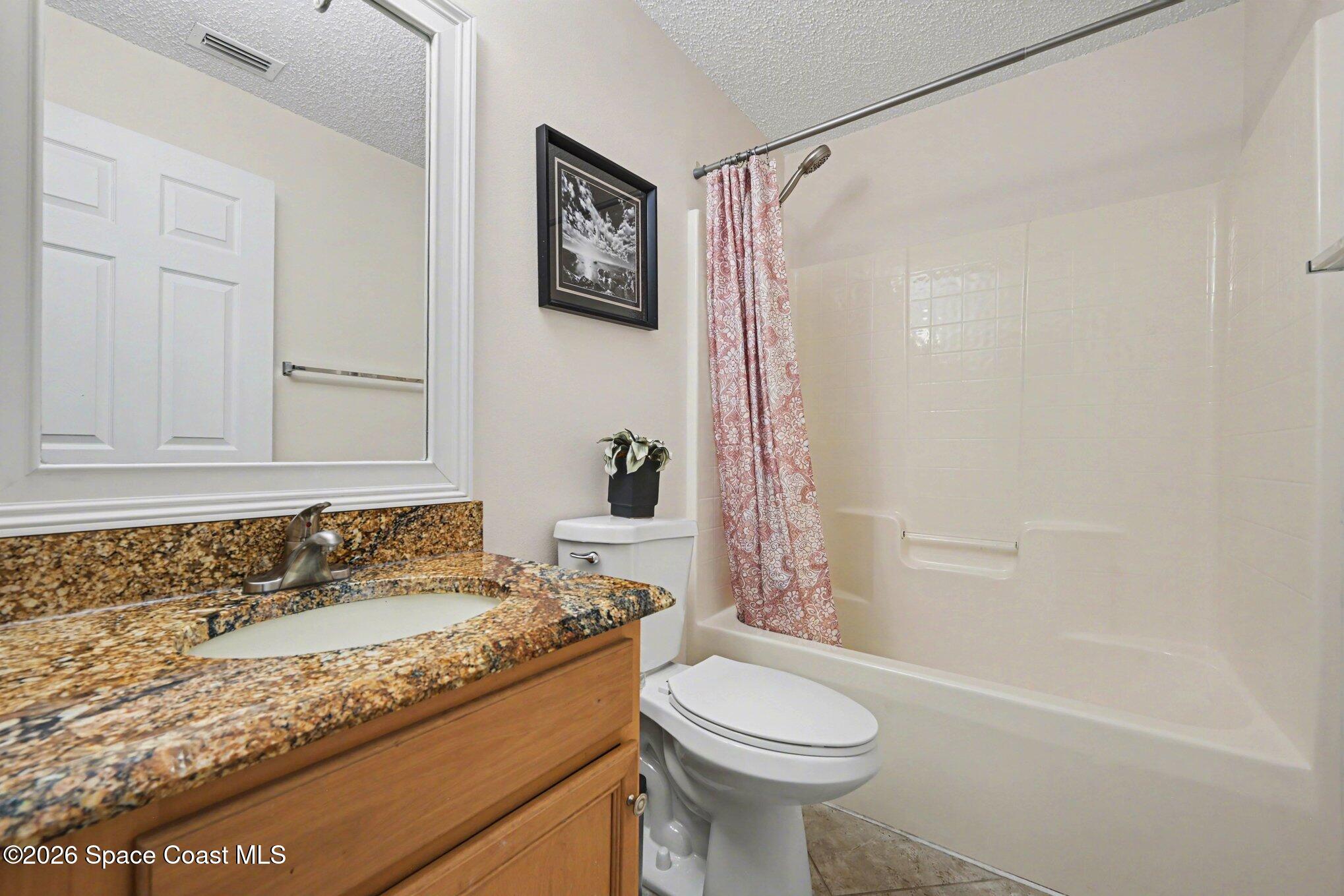558 Barber Street Sebastian, FL 32958 - Photo 22 of 25 a bathroom with a granite countertop sink a toilet and shower