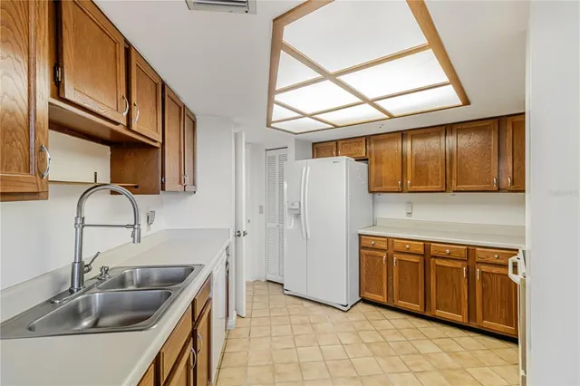 a kitchen with stainless steel appliances granite countertop a sink and a refrigerator