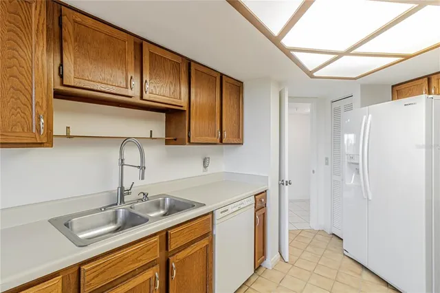 a kitchen with stainless steel appliances granite countertop a sink refrigerator and cabinets