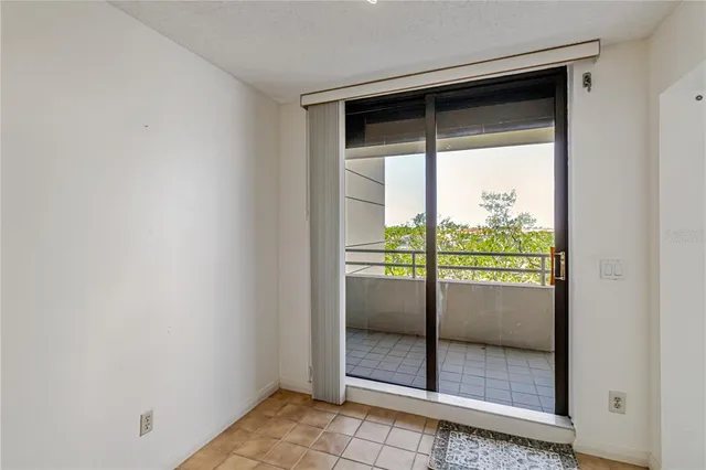 a spacious bedroom with a bed and a flat screen television