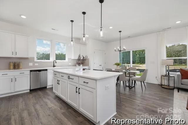 a kitchen with kitchen island granite countertop a sink cabinets and wooden floor