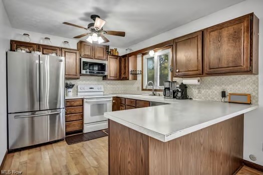 12200 Chamberlain Road Aurora, OH 44202 - Photo 12 of 33 Kitchen featuring tasteful backsplash, stainless steel appliances, ceiling fan, and kitchen peninsula