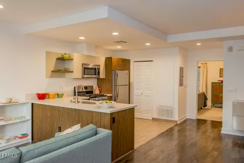a room with a sink wooden floor and cabinets