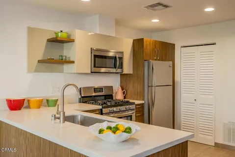 a kitchen with stainless steel appliances a stove refrigerator sink and microwave