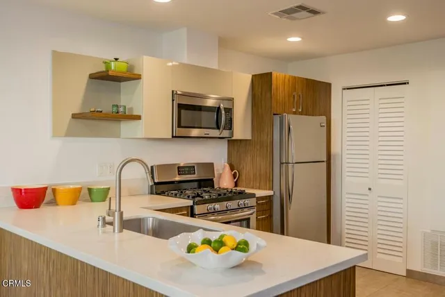 a kitchen with stainless steel appliances a stove refrigerator sink and microwave
