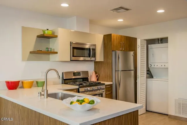 a kitchen with stainless steel appliances a sink refrigerator microwave and cabinets