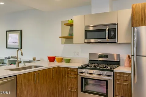 a kitchen with stainless steel appliances a stove microwave and sink