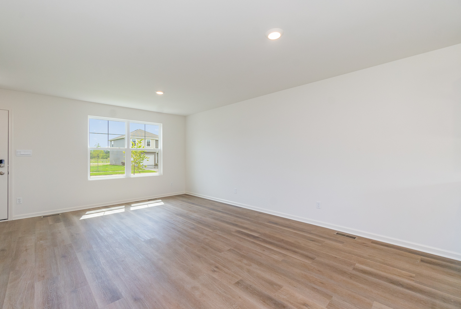 600 Adirondack Court Joliet, IL 60421 - Photo 2 of 19 an empty room with wooden floor and windows