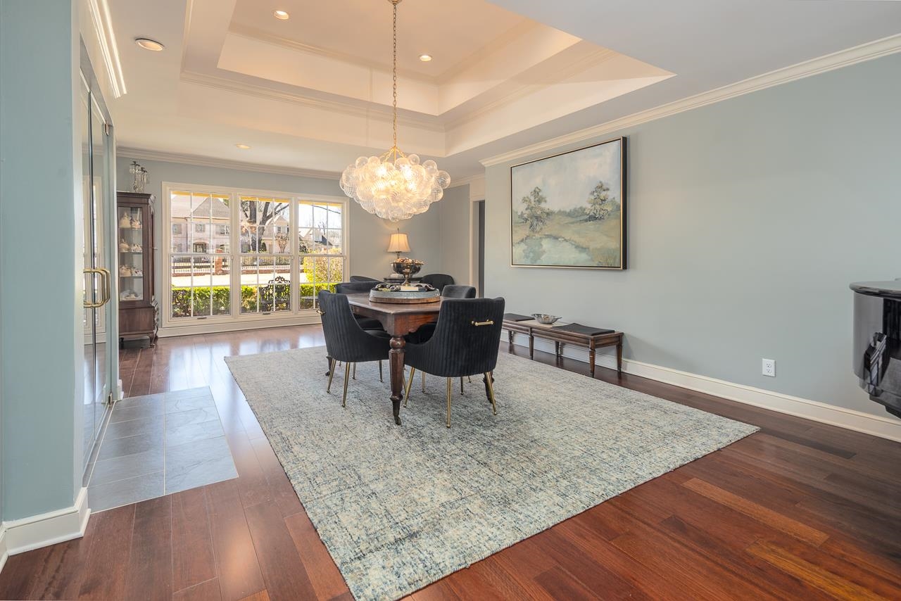 4723 Gwynne Road Memphis, TN 38117 - Photo 12 of 40 a dining room with wooden floor a chandelier a wooden table and chairs