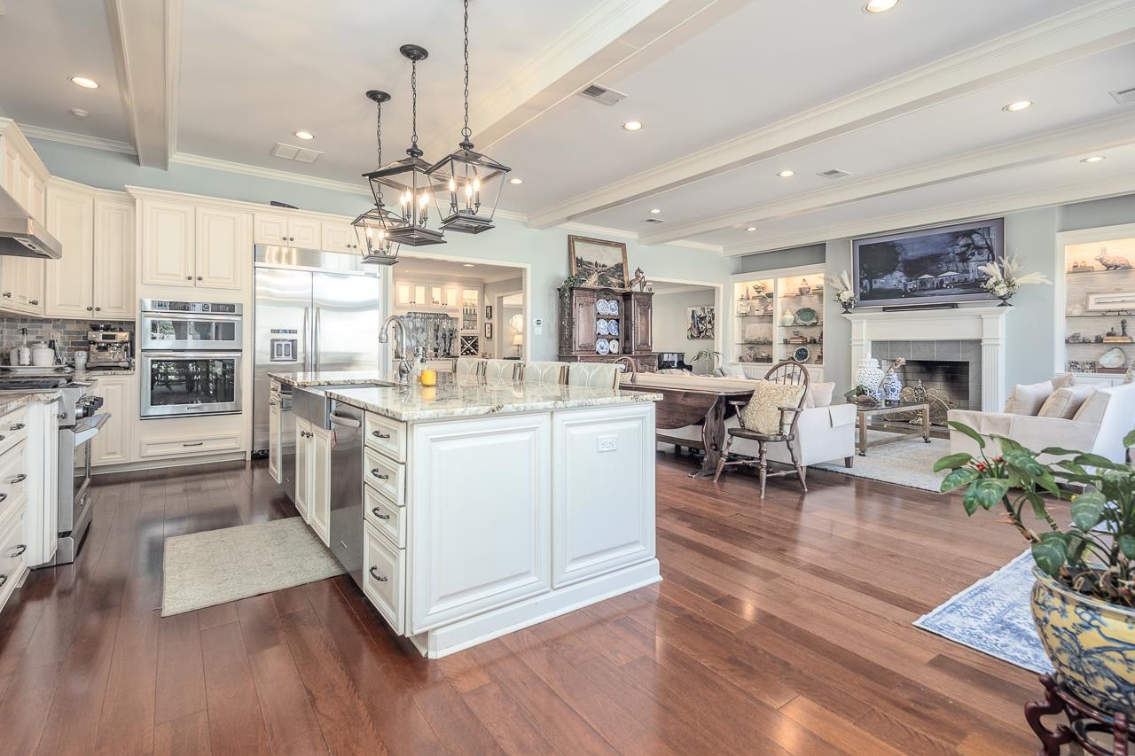 4723 Gwynne Road Memphis, TN 38117 - Photo 7 of 40 a kitchen with stainless steel appliances granite countertop a stove top oven a sink dishwasher and a dining table with wooden floor