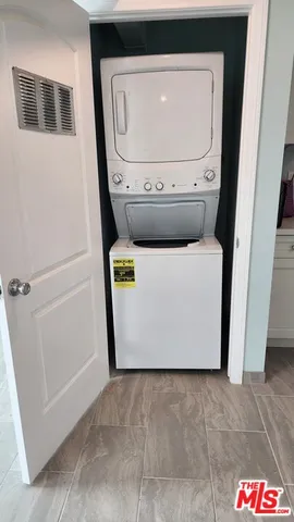 a view of a white house with a small yard and potted plants