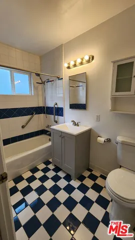 a kitchen with a checkered floor and white cabinets with a black white checkered floor