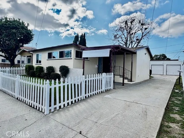 a view of a house with a small yard and wooden fence