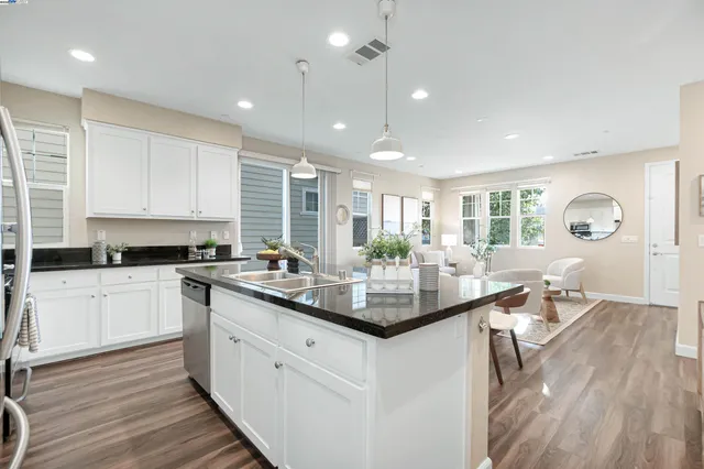 a kitchen with center island white cabinets and stainless steel appliances