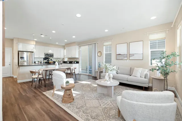 a living room with furniture kitchen and a large window