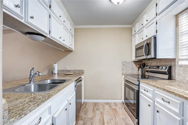 a kitchen with stainless steel appliances granite countertop a sink dishwasher stove and microwave with wooden cabinets