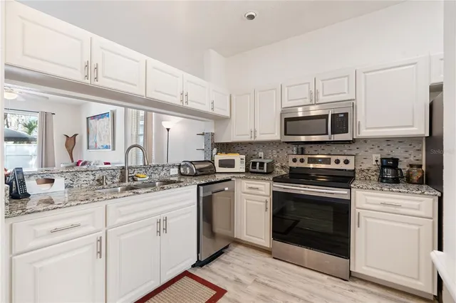 a kitchen with stainless steel appliances granite countertop a refrigerator sink and stove