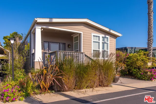 a view of a house with a small yard and potted plants