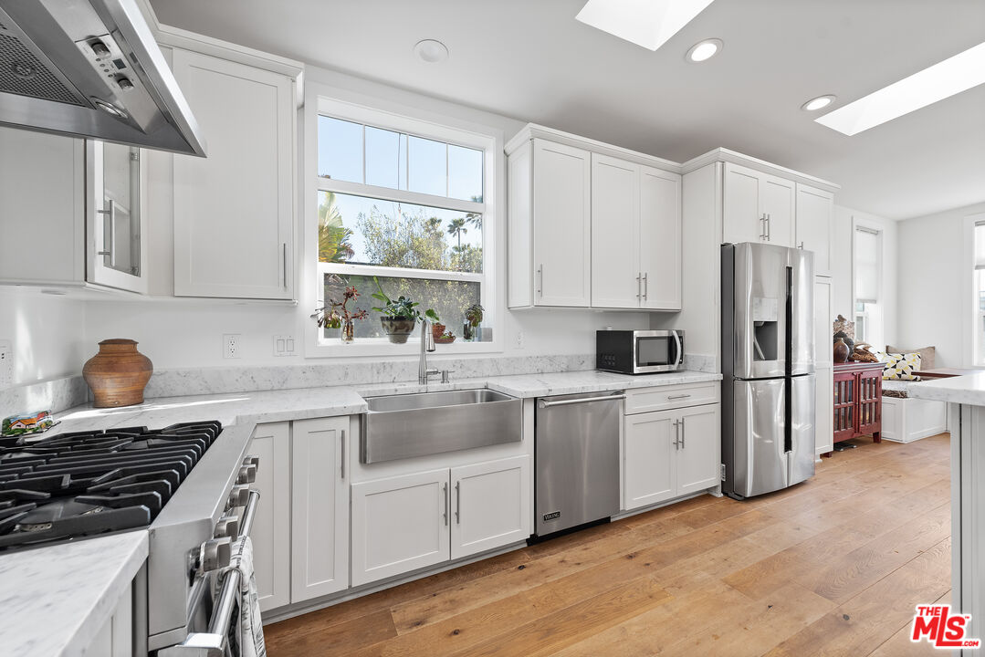 29500 Heathercliff Road, Unit 16 Malibu, CA 90265 - Photo 10 of 25 a kitchen with stainless steel appliances granite countertop a stove a sink dishwasher and a refrigerator