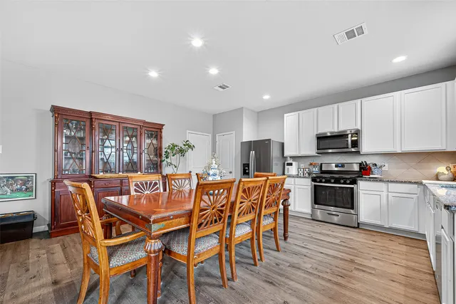 a view of a dining room with furniture kitchen and wooden floor