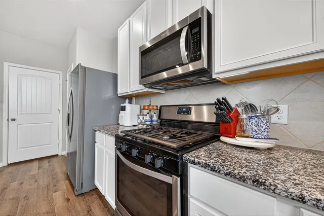 a kitchen with stainless steel appliances granite countertop a stove and a microwave
