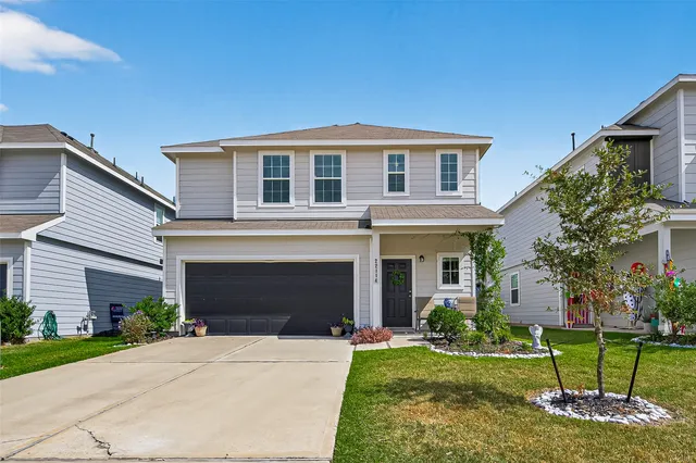 a front view of a house with a yard and garage