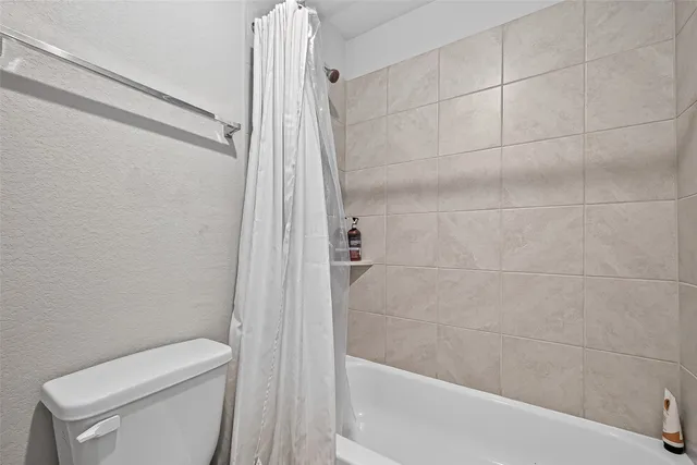 a bathroom with a toilet and shower