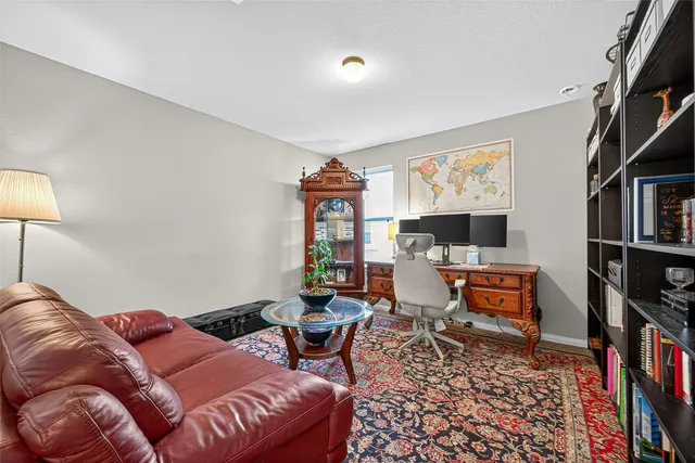 a living room with furniture a rug and a book shelf