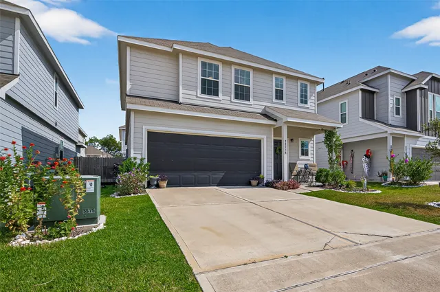 a front view of a house with a yard and potted plants