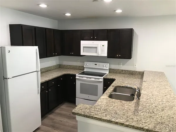 a kitchen with stainless steel appliances granite countertop a refrigerator and a stove
