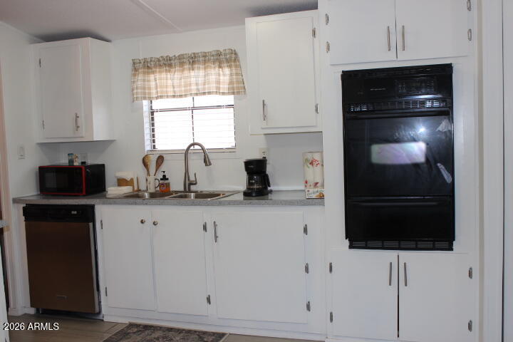 9501 East Broadway Road, Unit 101 Mesa, AZ 85208 - Photo 7 of 24 a kitchen with white cabinets and black appliances