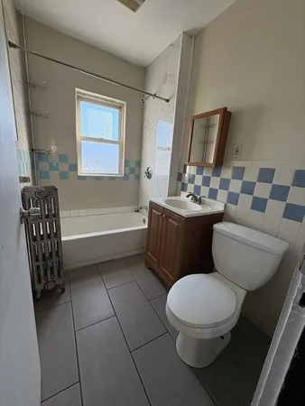 a bathroom with a toilet sink and mirror