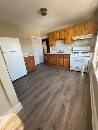 a kitchen with stainless steel appliances a stove top oven a sink and a refrigerator