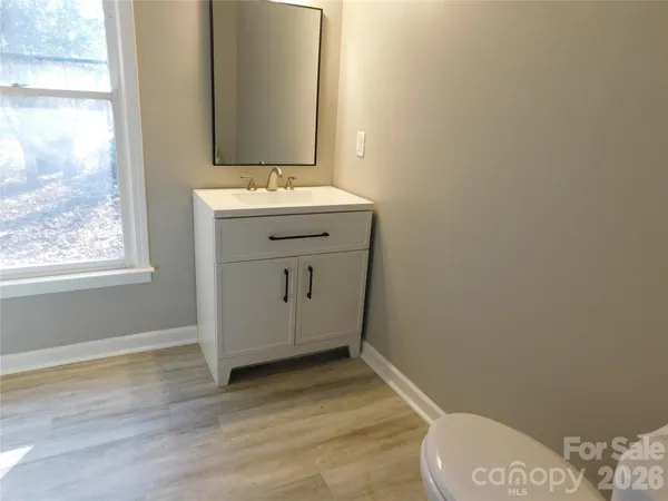 a bathroom with a sink toilet and window