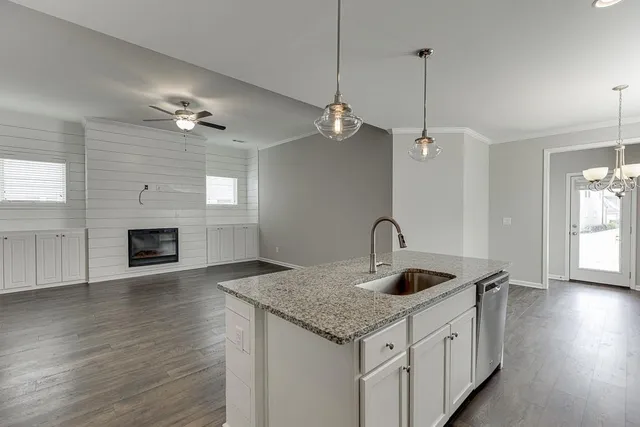a kitchen with kitchen island a sink stainless steel appliances and a fireplace