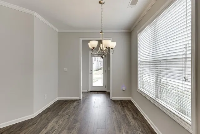 a view of a room with wooden floor and windows
