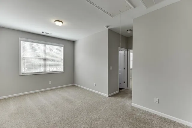 an empty room with a window and closet area
