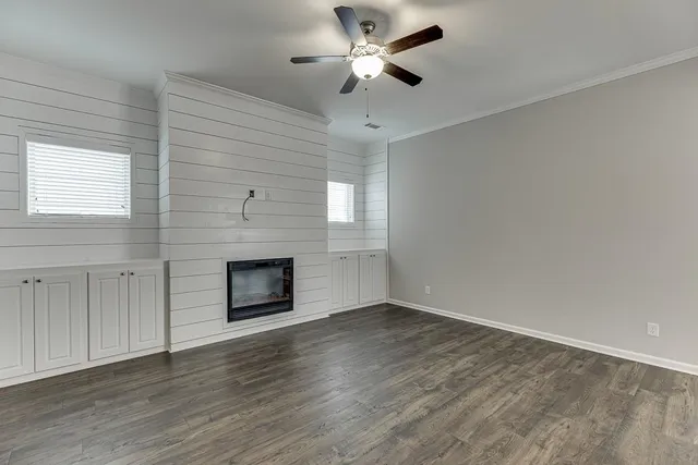 a view of an empty room with a fireplace and a window