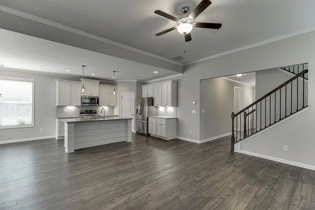 a kitchen with stainless steel appliances kitchen island wooden floors granite counter tops and a window