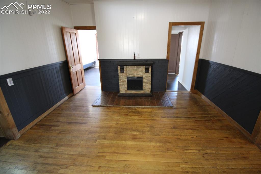 1526 Noe Road Larkspur, CO 80118 - Photo 12 of 29 a view of a livingroom with wooden floor and a fireplace